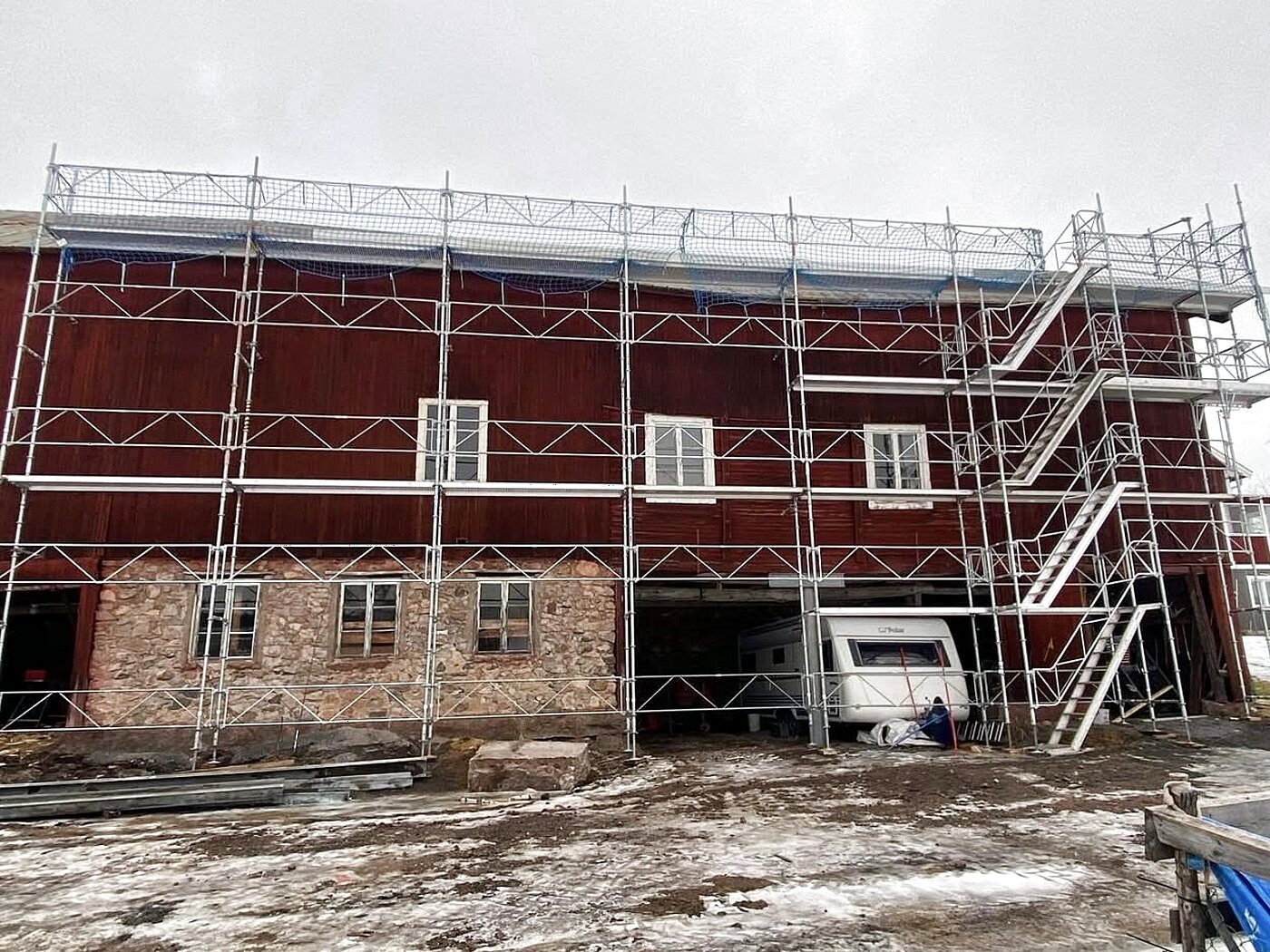 Takställning med fallskyddsnät och trappa monterad på en ladugård för säkert takarbete