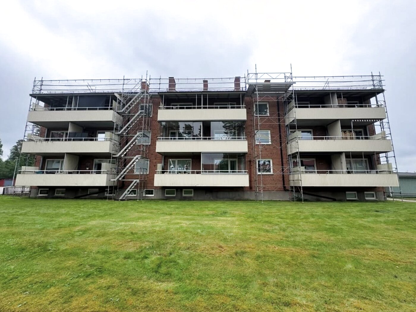 Byggställning anpassad kring balkonger på ett bostadsrättshus under balkongrenovering